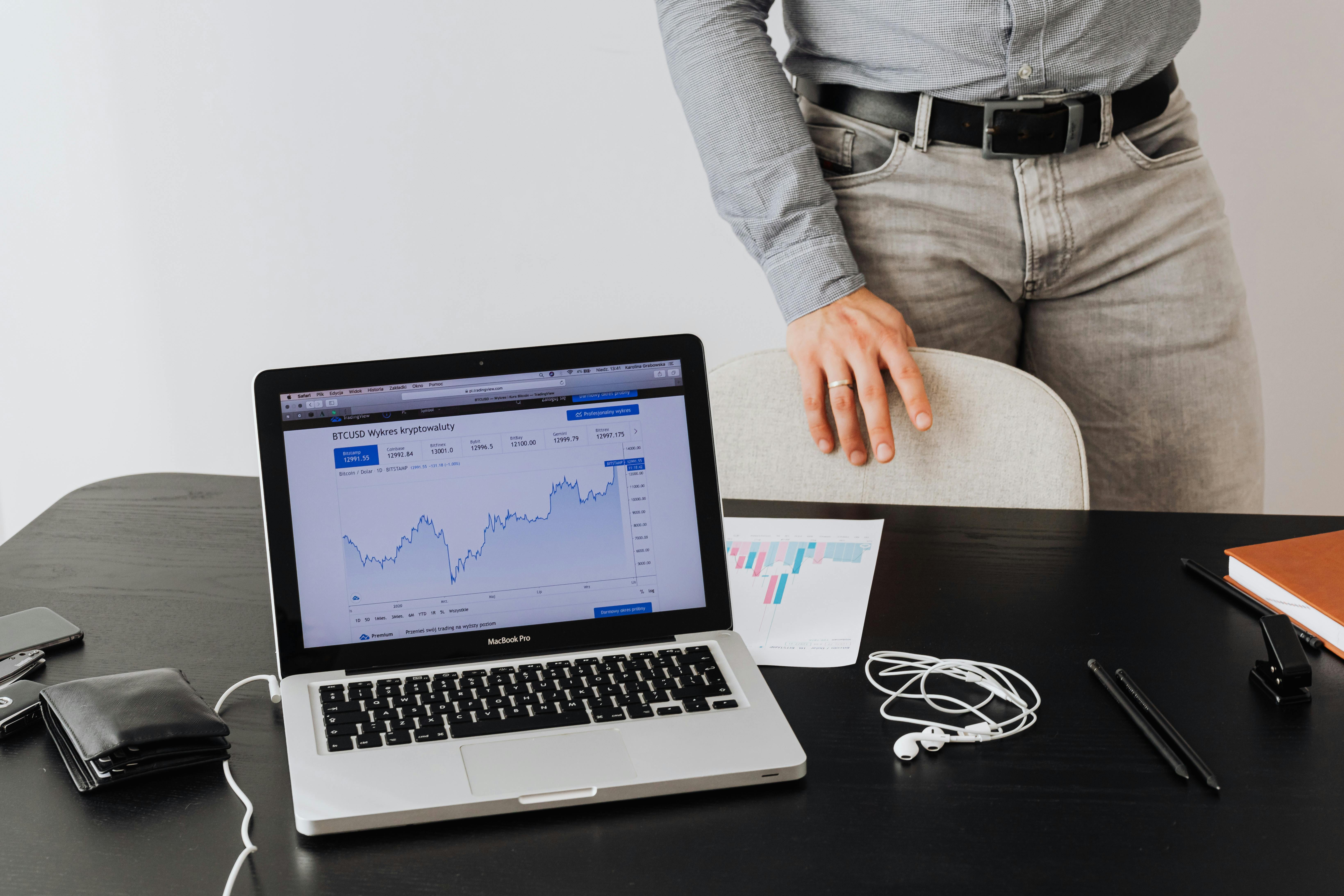Mesa com laptop e gráfico de Bitcoin